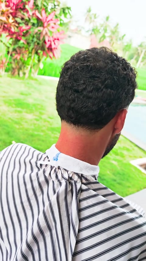 Curly haircut with a taper fade at the neckline