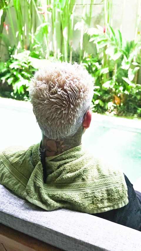 Blonde hair color with textured curls and closely tapered sides